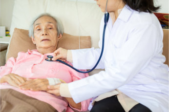 elderly woman in bed being checked